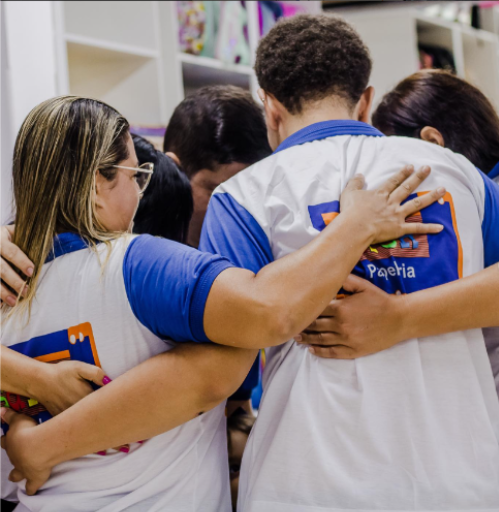 Foto da equipe da Papelaria Saron se abraçando